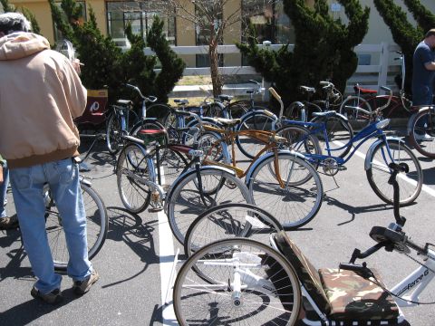 1994 Ford Bronco - A variety of vintage-style bicycles are parked together on a paved surface under a bright sky.