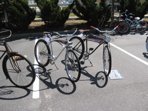 1994 Ford Bronco - A collection of vintage-style cruiser bicycles are displayed outdoors, casting long shadows on the pavement.