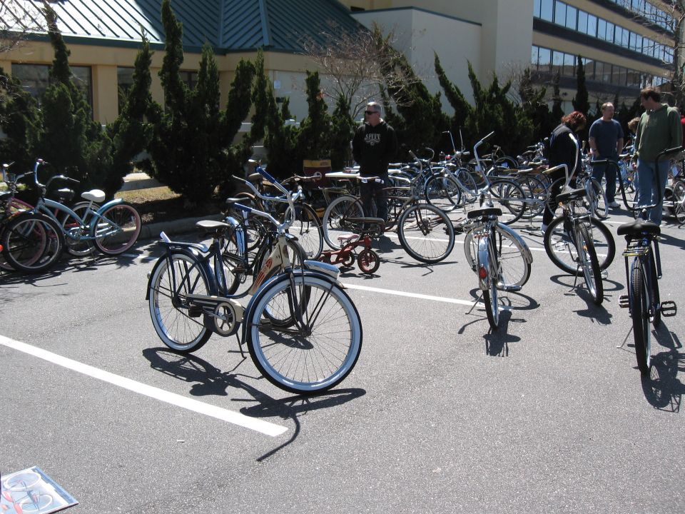 Multiple bicycles and a small red tricycle parked in a lot