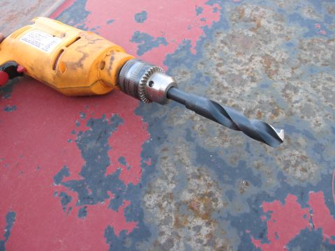 1981 Ford Bronco - A yellow power drill with a large drill bit is shown on a weathered surface. The registry claims it is a 1981 Ford Bronco part.