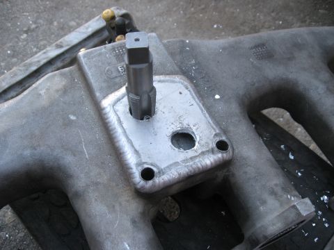1981 Ford Bronco - A tap tool is used to create threads in a metal plate welded onto an engine intake manifold.