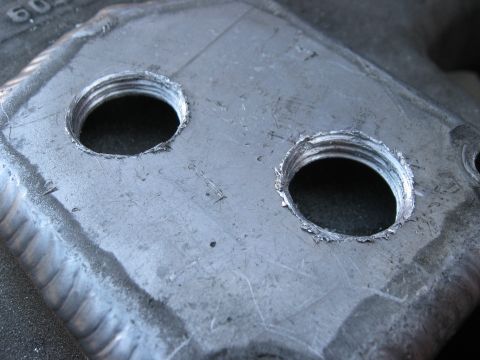 1981 Ford Bronco - Close-up of a metal component with two threaded openings and visible weld seams.