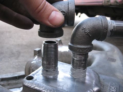 1981 Ford Bronco - Assembling threaded metal plumbing fittings onto a component.