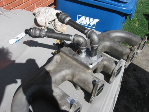1981 Ford Bronco - Close-up of a custom intake manifold with added pipework, resting outdoors.