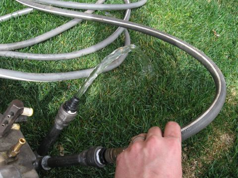 1981 Ford Bronco - Water flows through a garden hose connected to a metal pipe assembly on grass.
