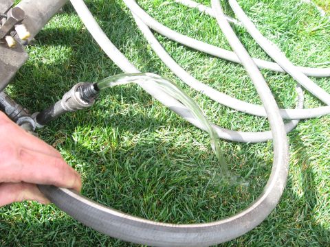 1981 Ford Bronco - Water is being directed from one hose to another on a grassy surface.