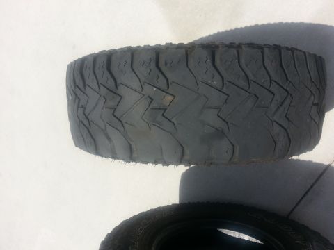 1994 Ford Bronco - A single tire is shown with its tread pattern clearly visible, another tire is partially visible underneath.