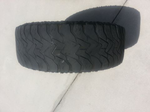 1994 Ford Bronco - A single tire is shown, resting on a flat surface with its tread pattern clearly visible.