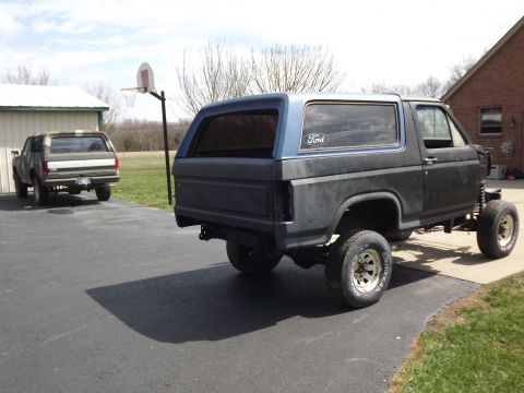 1981 Ford Bronco - A modified Ford Bronco sits in a driveway next to another SUV.