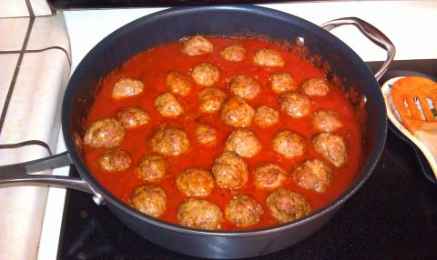 1989 Ford Bronco - Skillet of meatballs in marinara sauce with a wooden spoon rest on the side.