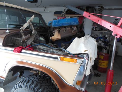 1979 Ford F-150 - Engine hoist lowering a blue-topped engine into the engine bay of a 1979 Ford F-150.