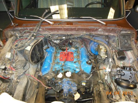 1979 Ford F-150 - The engine bay of a vehicle is shown with the hood removed, revealing the engine and surrounding components.