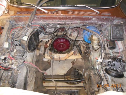 1979 Ford F-150 - The engine bay of a 1979 Ford F-150 shows the transmission, brake master cylinder, and various hoses and wiring.