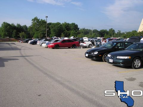1993 Ford Taurus - A gathering of cars in a parking lot, with a SHO Cal logo visible.