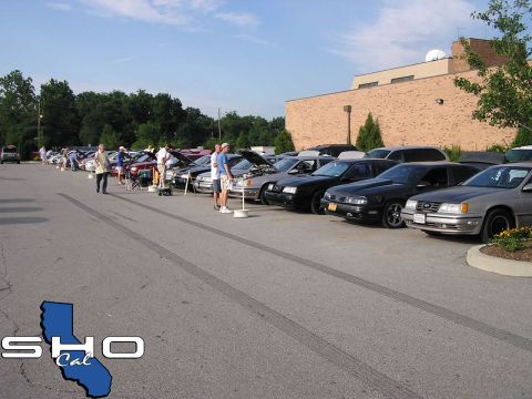 1993 Ford Taurus - A line of cars, including a silver 1992 Ford Taurus, are parked in a lot during a car show.