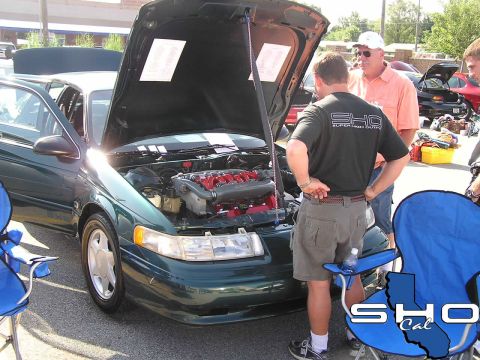 1993 Ford Taurus - Green 1993 Ford Taurus SHO at a car show, engine compartment open for viewing.