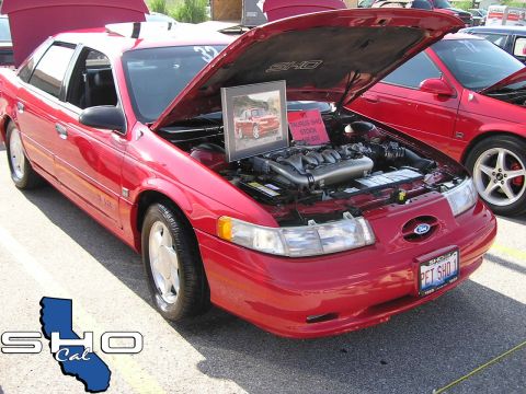 1993 Ford Taurus - 1993 Ford Taurus SHO on display, hood open to reveal the engine and a framed picture of the car.