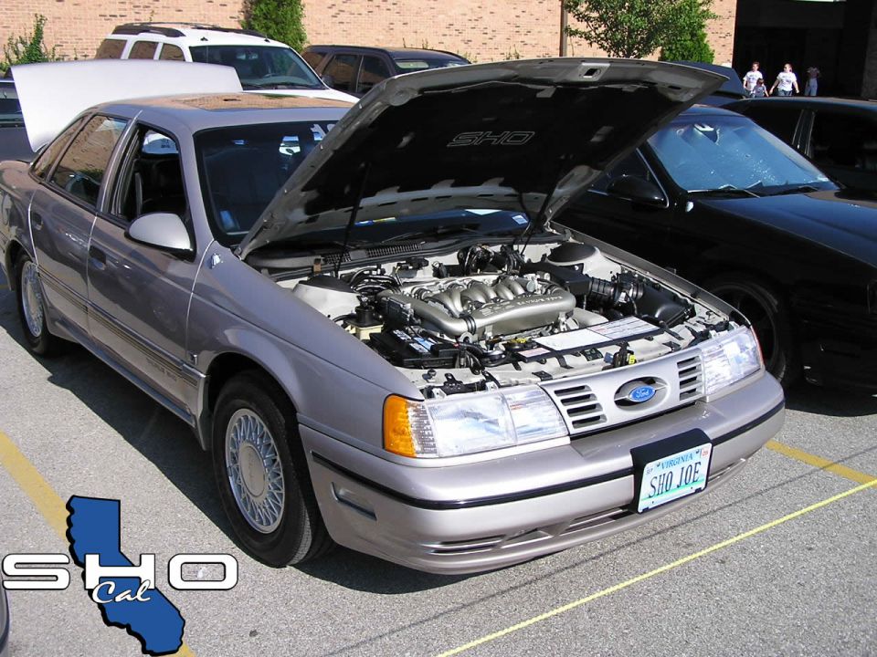 1993 Ford Taurus 3q-front view, silver, hood open revealing engine. California SHO Cal logo on lower left