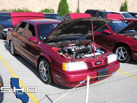 1993 Ford Taurus - A group of Ford Taurus SHO models are gathered, with one prominently displaying its engine.