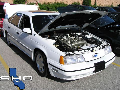 1993 Ford Taurus - White 1993 Ford Taurus SHO at an event, hood open to display the engine.