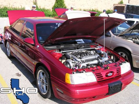 1993 Ford Taurus - A red 1993 Ford Taurus is displayed with its hood open, revealing its engine.