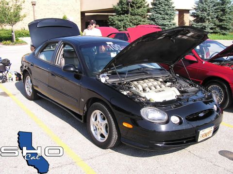 1993 Ford Taurus - Black Ford Taurus with hood and trunk open, parked next to a red car at an event.
