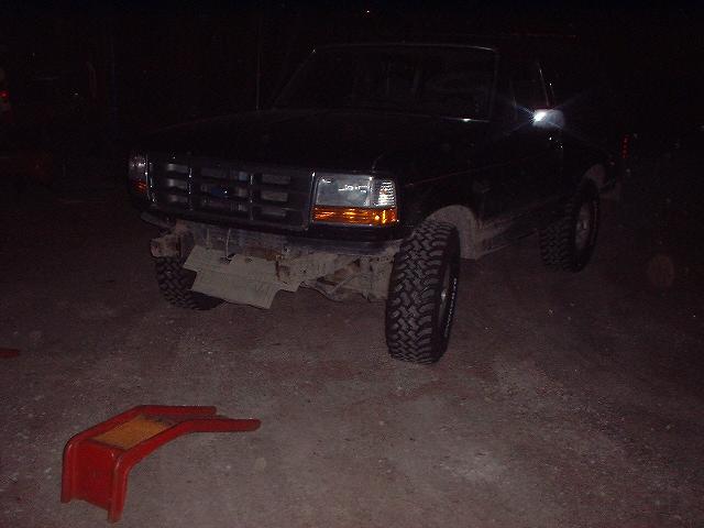 1993 Ford Bronco front view, bumper removed, parked at night