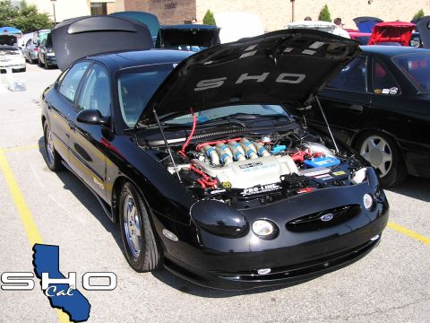 1993 Ford Taurus - A black Ford Taurus SHO is parked with its hood open, displaying its V8 engine and 'SHO' badging.