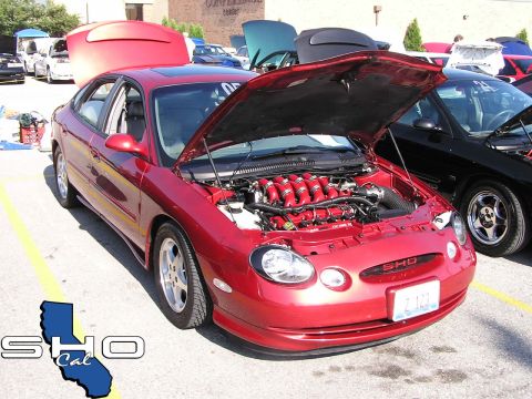 1993 Ford Taurus - This 2000 Ford Taurus SHO features a V8 engine with its hood open, displayed at an event.