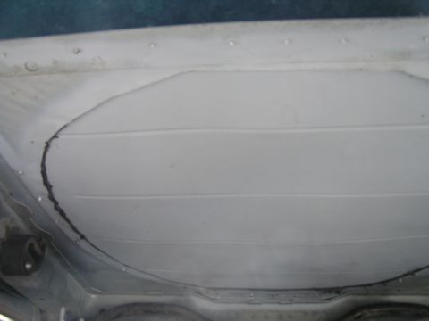 1993 Ford Taurus - The underside of a vehicle reveals a large, cracked panel, suggesting potential damage or wear.