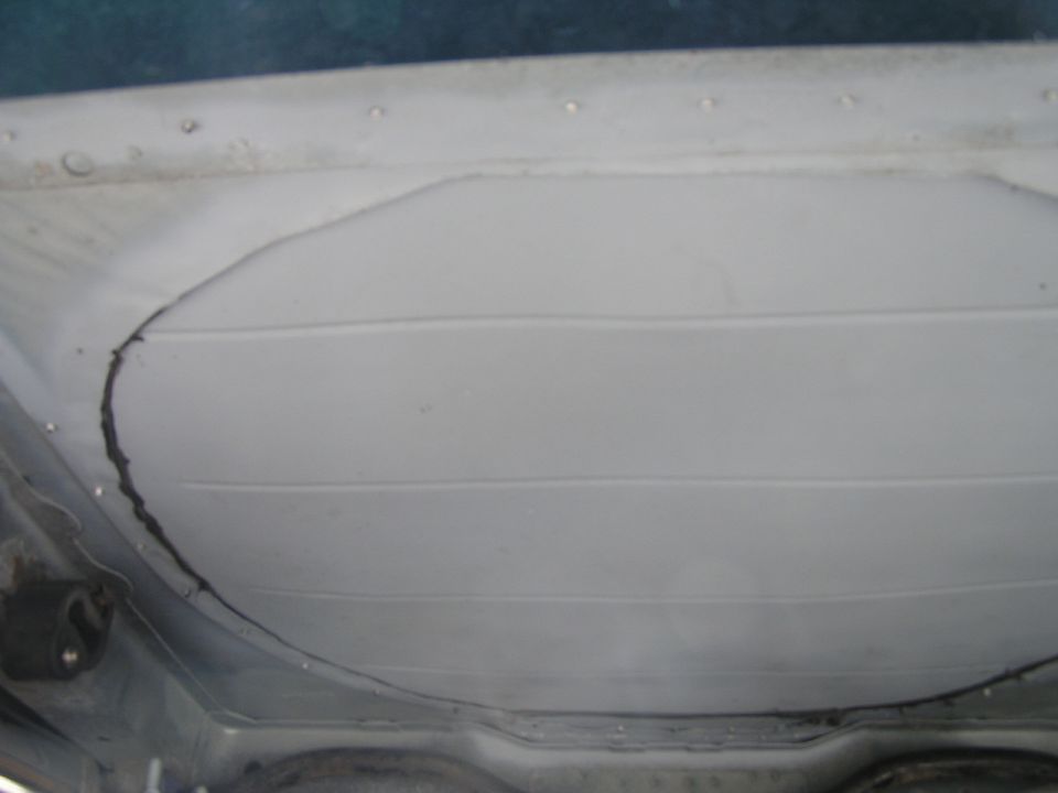 Underside of a car showing a large, cracked panel