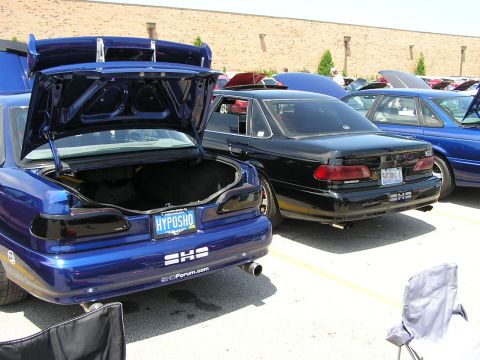 1993 Ford Taurus - Rear view of two Ford Taurus SHO models at a car meet, with one's trunk open.