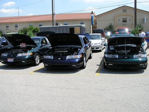 1993 Ford Taurus - Three 1993 Ford Taurus sedans are displayed with their hoods open, one of which has a 'For Sale' sign visible.
