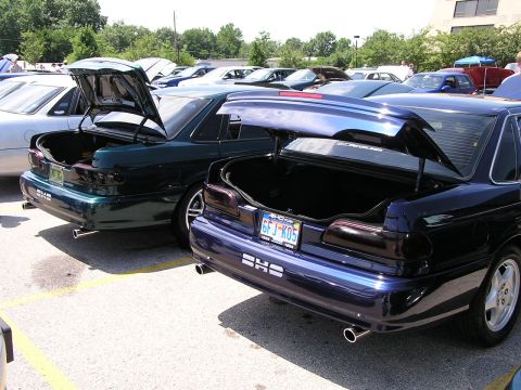 1993 Ford Taurus - Two Ford Taurus SHO models are parked side-by-side with their trunks open, displaying their rear ends.