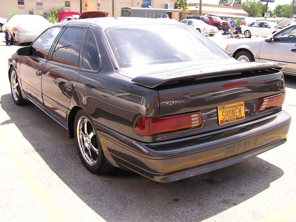 Dark gray 1993 Ford Taurus SHO sedan, rear view, with a spoiler and custom wheels