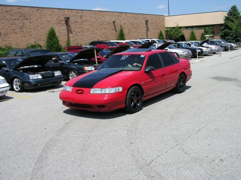 1993 Ford Taurus - Red 1993 Ford Taurus sedan with black hood stripe and black wheels at a car meet.