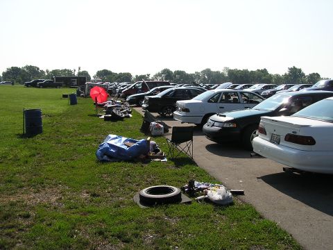 1993 Ford Taurus - A row of cars is parked on a sunny day, with a dark green 1993 Ford Taurus prominently featured.