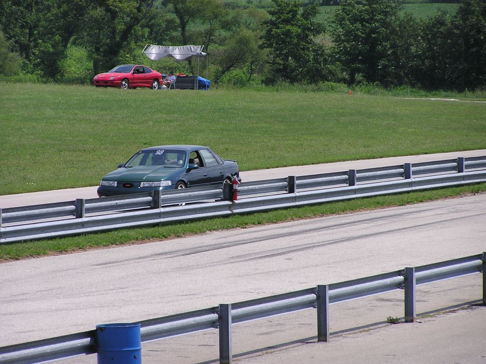 Green 1993 Ford Taurus on racetrack, number 98 on windshield