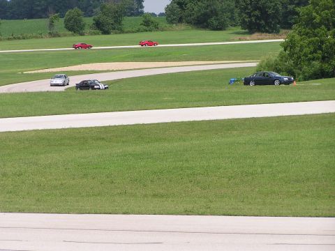 1993 Ford Taurus - Multiple vehicles are seen on a race track during what appears to be a track day event.