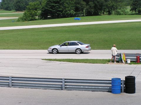 1993 Ford Taurus - Silver sedan on a race track, possibly a mid-1990s model, with a person observing.