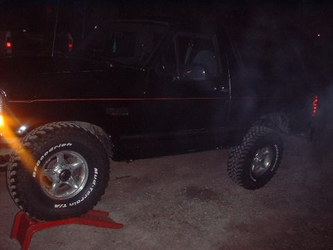 1993 Ford Bronco - 1993 Ford Bronco with BFGoodrich Mud-Terrain T/A tires, front wheel elevated on a red jack.