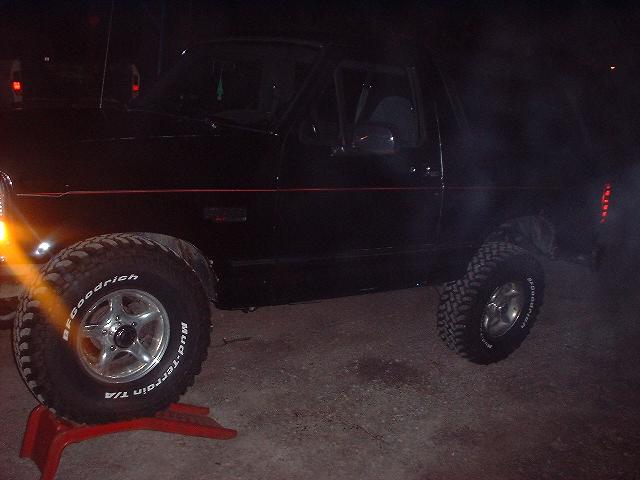 1993 Ford Bronco side view, front wheel on red jack, BFGoodrich Mud-Terrain T/A tires