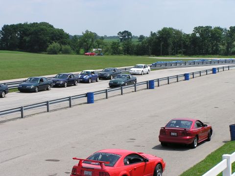 1993 Ford Taurus - Cars on a racetrack during an event, with a focus on the track and surrounding landscape.