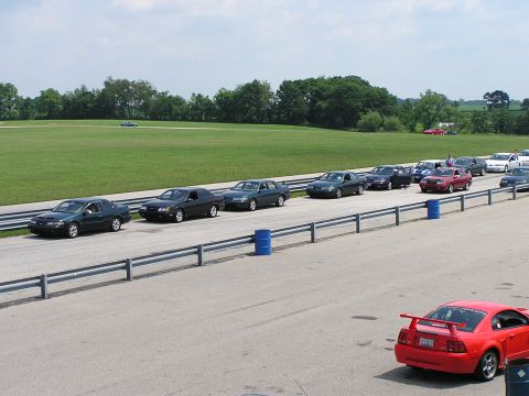 1993 Ford Taurus - A group of 1993 Ford Tauruses are lined up on a racetrack, ready for an event.