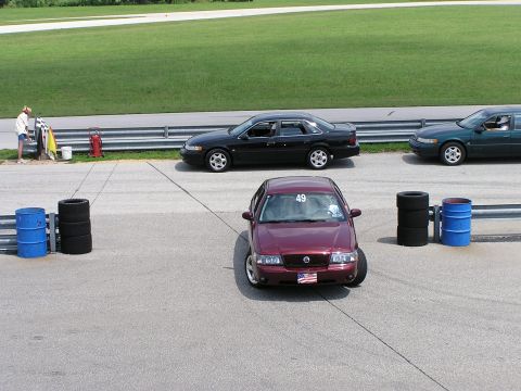 1993 Ford Taurus - Three sedans are lined up on a racetrack, with one prominently in the foreground.