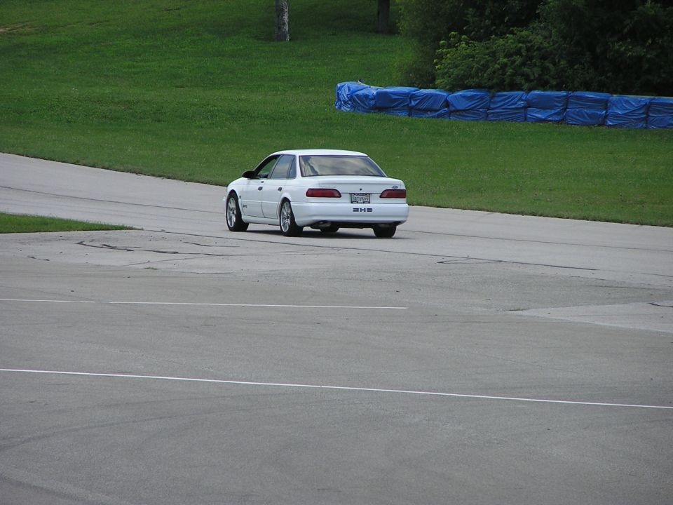 1993 Ford Taurus sedan on a race track, rear view. License plate is visible