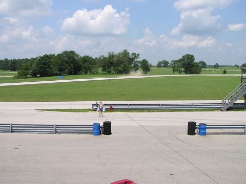 1993 Ford Taurus - A sunny day at the race track with a person observing the action.