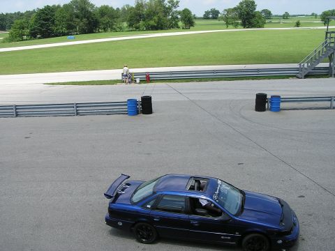 1993 Ford Taurus - Blue 1993 Ford Taurus sedan with spoiler and sunroof parked on a racetrack.