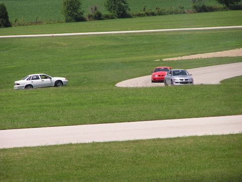 1993 Ford Taurus - Three cars are visible on a grassy area next to a paved track.