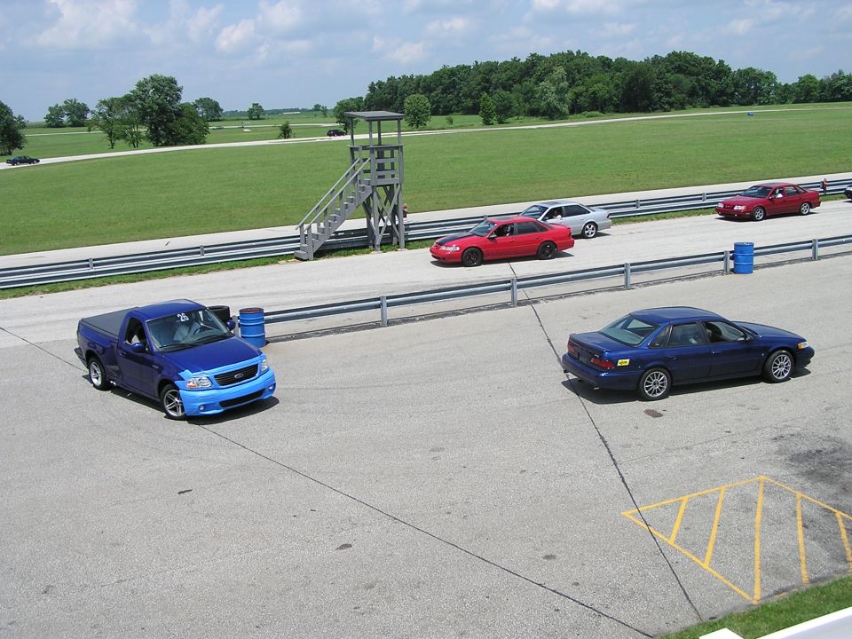 Blue Ford F-150 Lightning pickup truck with blue and light blue front end on a racetrack